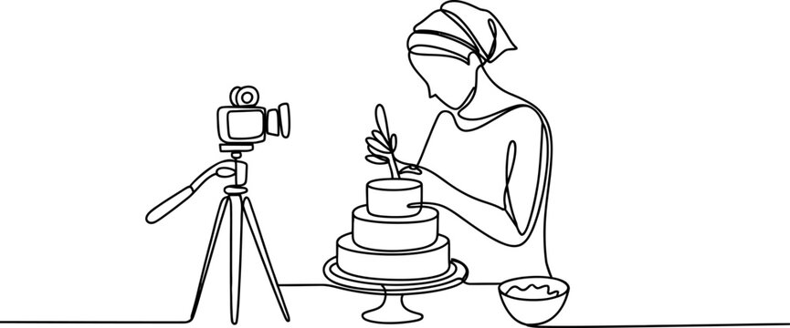 Woman recording a video of herself decorating a birthday cake with a camera on a tripod
