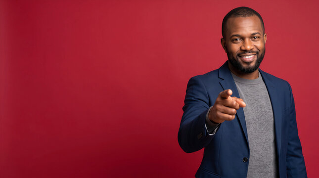 Confident smiling African American businessman pointing at camera with copy space
