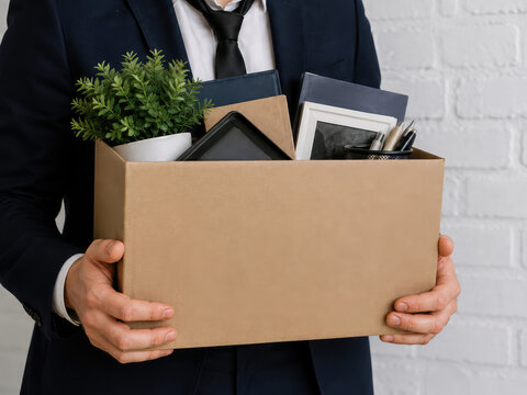 Laid Off Employee Carrying Office Belongings in Cardboard Box