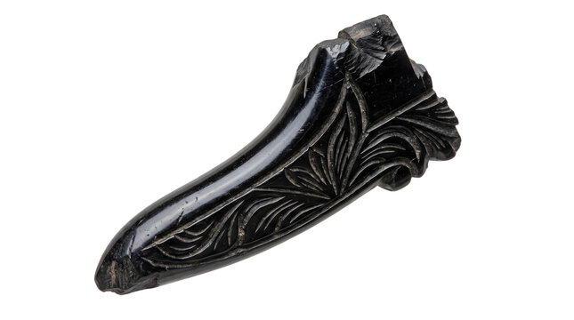 Antique carved obsidian stone relic features dark floral patterns and polished black finish for historical museum displays and cultural archaeological exhibits.