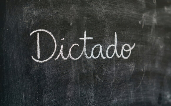 Dictado escrito en pizarra negra con tiza blanca para educacion escolar y aprendizaje de ortografia y gramatica