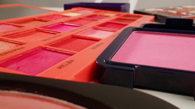 Multi Coloured Rainbow Make up Palette with Colourful make up brushes close up, macro in shop. 