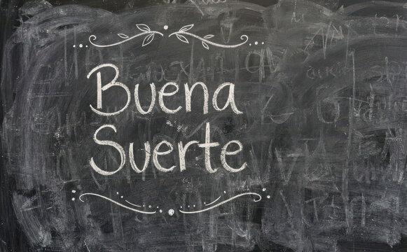Buena Suerte escrito en pizarra con tiza como concepto de motivacion y exito en espanol