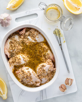 A baking dish filled with chicken thighs covered in homemade marinade.
