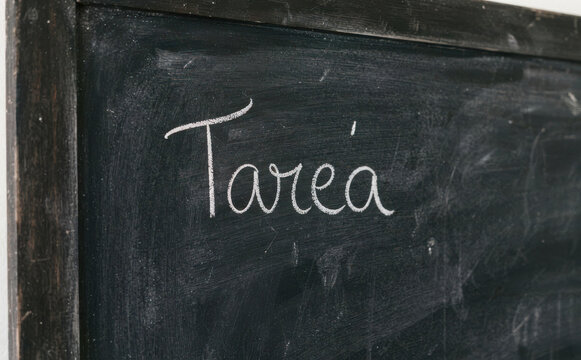Tarea escrito en pizarra escolar con tiza blanca concepto educativo y de deberes escolares