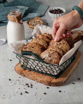 A hand reaching into a basket of delicious quinoa chocolate chip cookies.
