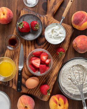 Top down view of fresh ingredients for making a homemade strawberry peach cake.