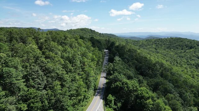 A single car traveling a road through Oconee State Park with the foothills in the background in northwest South Carolina.