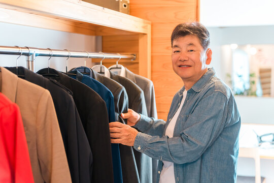 A senior man choosing clothes in the walk-in closet of his home.