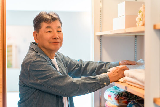 A senior man choosing clothes in the walk-in closet of his home.
