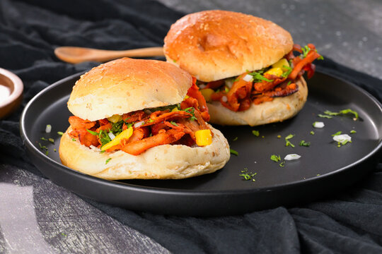 Authentic Mexican food photography featuring al pastor pork tortas with pineapple and onions on a black plate with background details