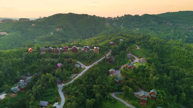 Mountain houses among green trees and dramatic peaks with panoramic views in a quiet highland resort community