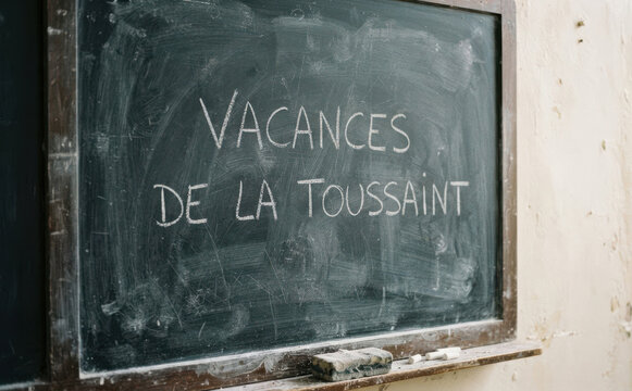 VACANCES DE LA TOUSSAINT ecrit sur un tableau noir ecole rentree education automne