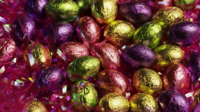 Colorful foil wrapped chocolate easter eggs in pile