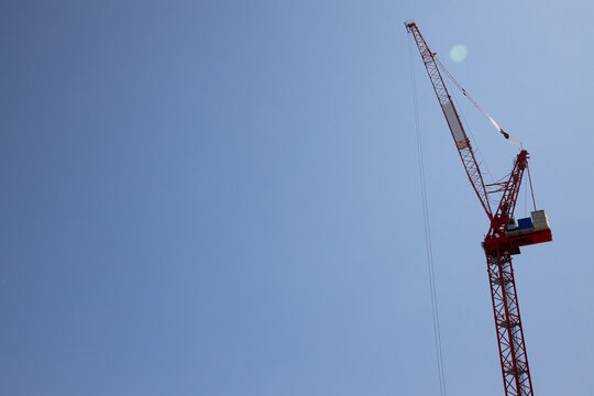 Construction crane lifts materials high above a bustling city