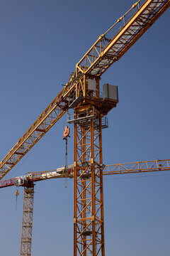 Construction crane operates at high-rise building site in urban environment