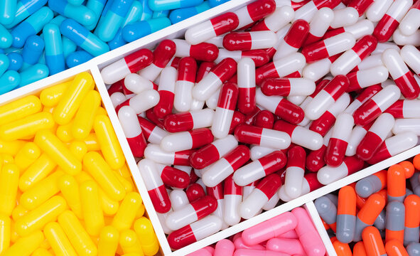 Top view of colorful capsule pills in plastic tray. Pharmaceutical industry. Healthcare and medicine. Drug production. Pharmaceutics concept. Vitamins and supplements capsules. Bright color capsule.