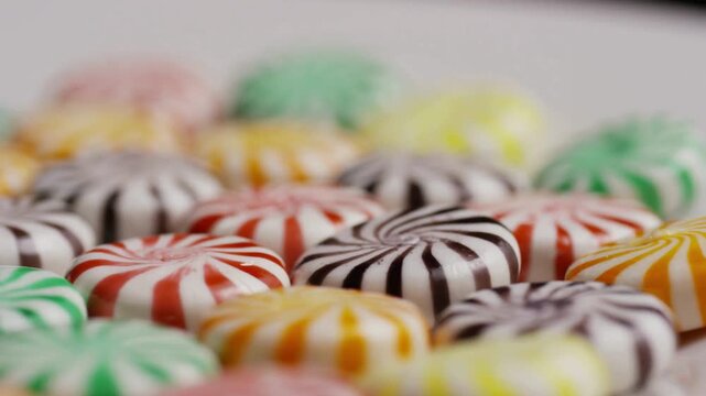 Rows of colorful peppermint swirl hard candies on white