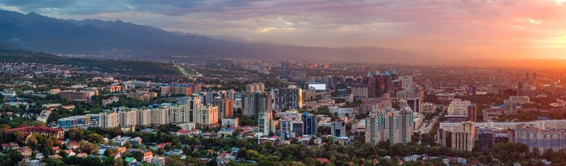 Fototapeta premium A picturesque drone view of the Kazakh city of Almaty at sunset on a summer evening.