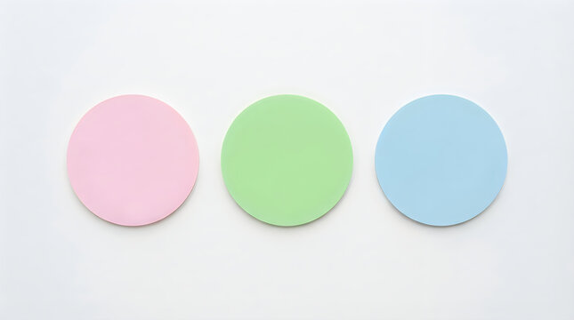Three colorful round badges or stickers in pink, green, and blue colors
