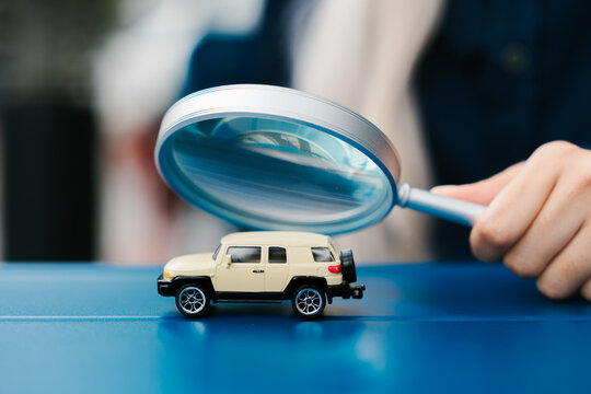 Magnifying glass examining toy car model vehicle inspection zoom focus curious detail automotive analysis scrutiny
