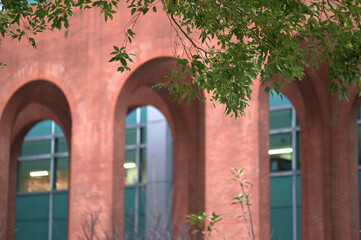 Fototapeta premium New Taipei City, Taiwan - Jan 05, 2025: Red brick arches line a corridor at the National Taiwan Library, glass facade beyond, No. 4 Park, Zhonghe District.