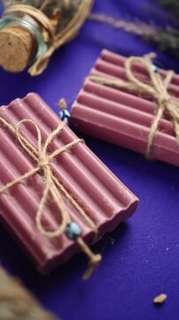 Soap bars with decorative string, purple background