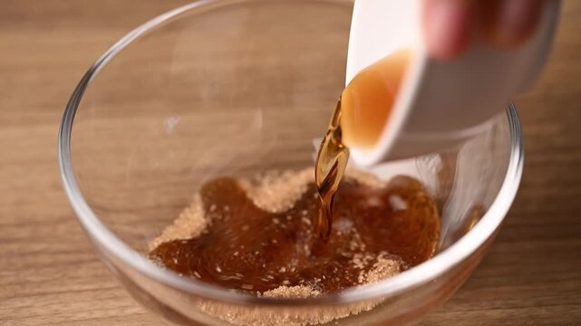 Close-up of preparing spicy Thai salad dressing in a glass bowl for glass noodle salad (Yum Woon Sen)