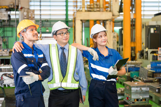 Confident industrial team of engineers and workers in manufacturing factory, successful manufacturing team of technicians and supervisor in plant