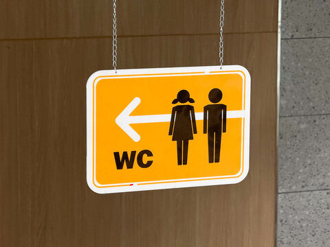 WC Restroom Sign Hanging from Ceiling with Directional Arrow