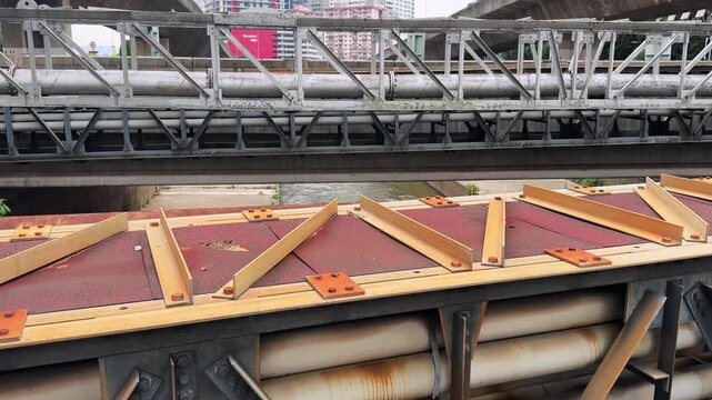 Industrial Steel Bridge Girders and Truss pipeline Structure over the river with Urban Background