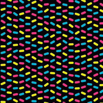 Colorful neon sprinkles pattern on black backdrop offers retro eighties vibes for party decor and textile print.
