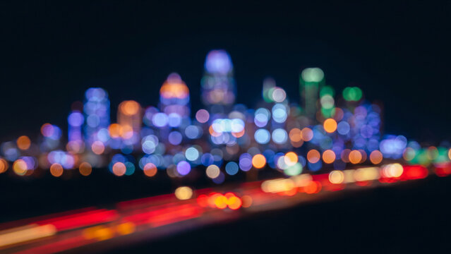 漆黒の空間に赤と黄の玉ボケが光跡を描く抽象的な都市の夜景シルエット背景