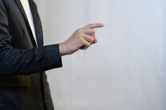 Businessman in Suit Pointing with Index Finger against Neutral Background