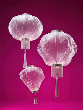 A group of three traditional Chinese lanterns recreated entirely from transparent inflated plastic, different rounded shapes and hanging tassels, soft wrinkles and inflated contours