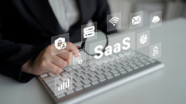 A business professional interacts with a keyboard while icons representing software as a service appear, emphasizing digital solutions and modern technology for enterprises. Ledger
