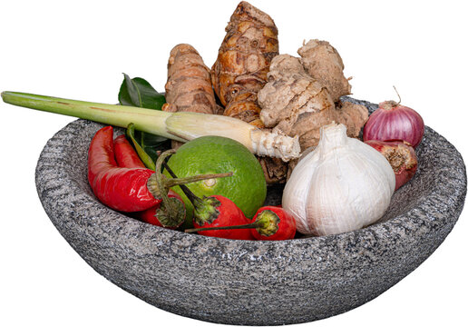 Raw soto ayam ingredients red chilies lemongrass green lime garlic ginger in stone mortar isolated on transparent background