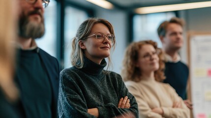 Obraz premium Diverse group of professionals in a modern office setting, attentively listening during a meeting or presentation.