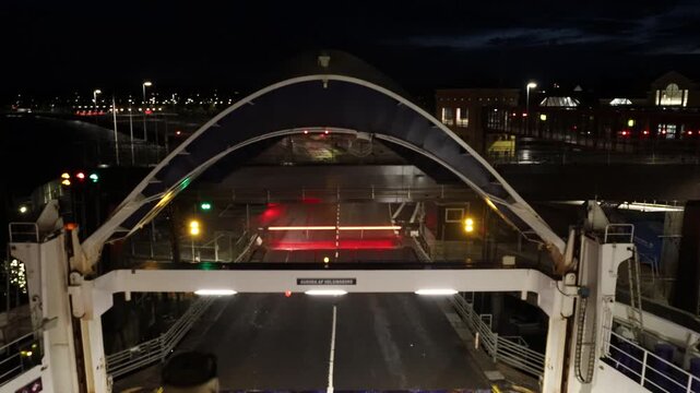 Helsingor, Denmark A roll-on/roll-off car ferry to Sweden at night loads from a movable bow section and departs from the dock. 