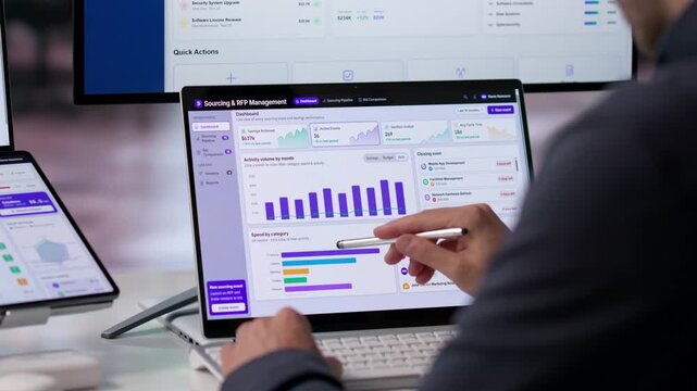 Procurement Manager Analyzes Software On Dual Screen Laptop