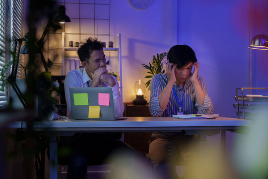 Asian businessmen stressed while working late in night office setup