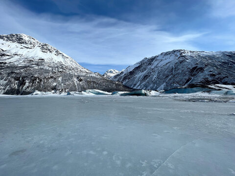 Frozen lake with mountains in the background on a winter day in Alaska. 