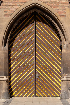 Striped wooden gate set inside a pointed Gothic arch