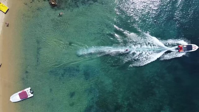 Cinematic drone footage of a person sea skiing through the waters of Skiathos.