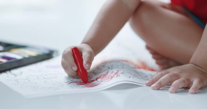 Child coloring with crayons on paper, art activity, creativity, early childhood education, learning, imagination, and child development, close-up