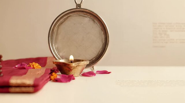 Karwa chauth ritual items featuring sieve and diya for traditional prayer
