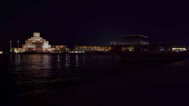 Museum of Islamic Art Doha at night with silhouette of Arab boat