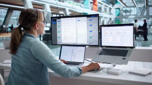 Young Woman Using Laptop To Organize Documents In Office Workspace