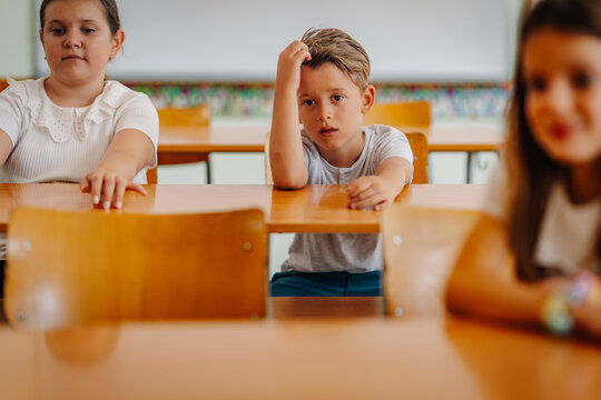 Elementary student sitting at desk looking thoughtful having difficulty learning