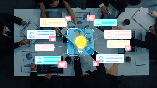 Group of diverse professionals brainstorming with digital feedback and colorful icons representing ideas and collaboration during a business meeting session. Entropy.